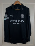 Black sports jersey with branding on a hanger against a white wall