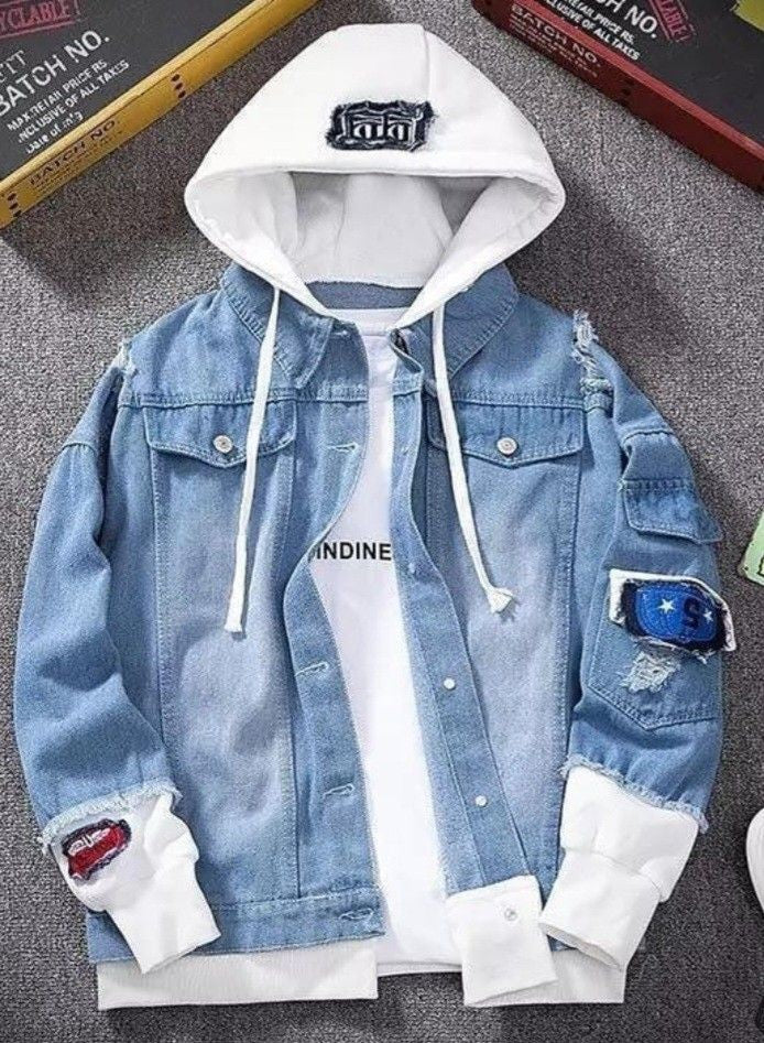 Blue denim jacket with white hoodie on a gray surface