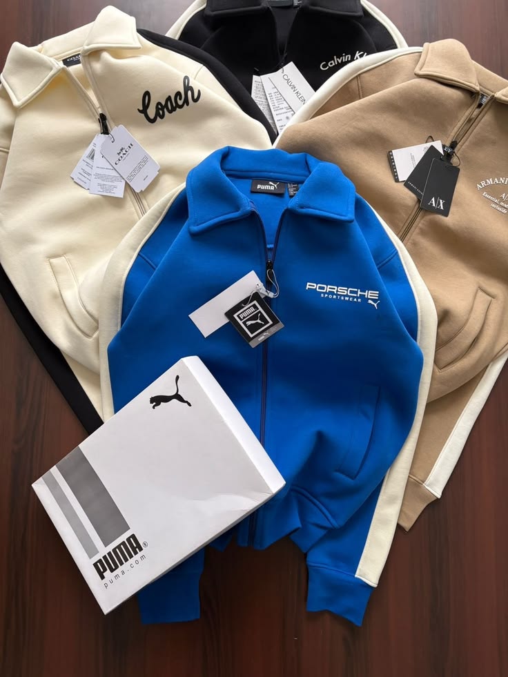 Collection of branded jackets with visible logos on a wooden surface