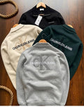 Four Calvin Klein Jeans sweatshirts in different colors on a wooden surface.