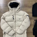 White puffer jacket with Nike logo on a wooden floor