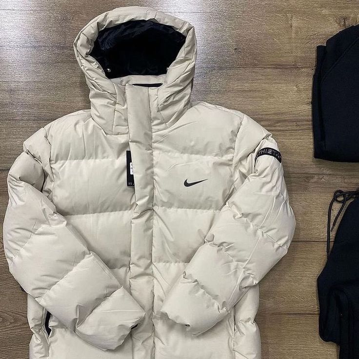 White puffer jacket with Nike logo on a wooden floor