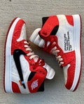 Red and white sneakers with black accents on a gray surface