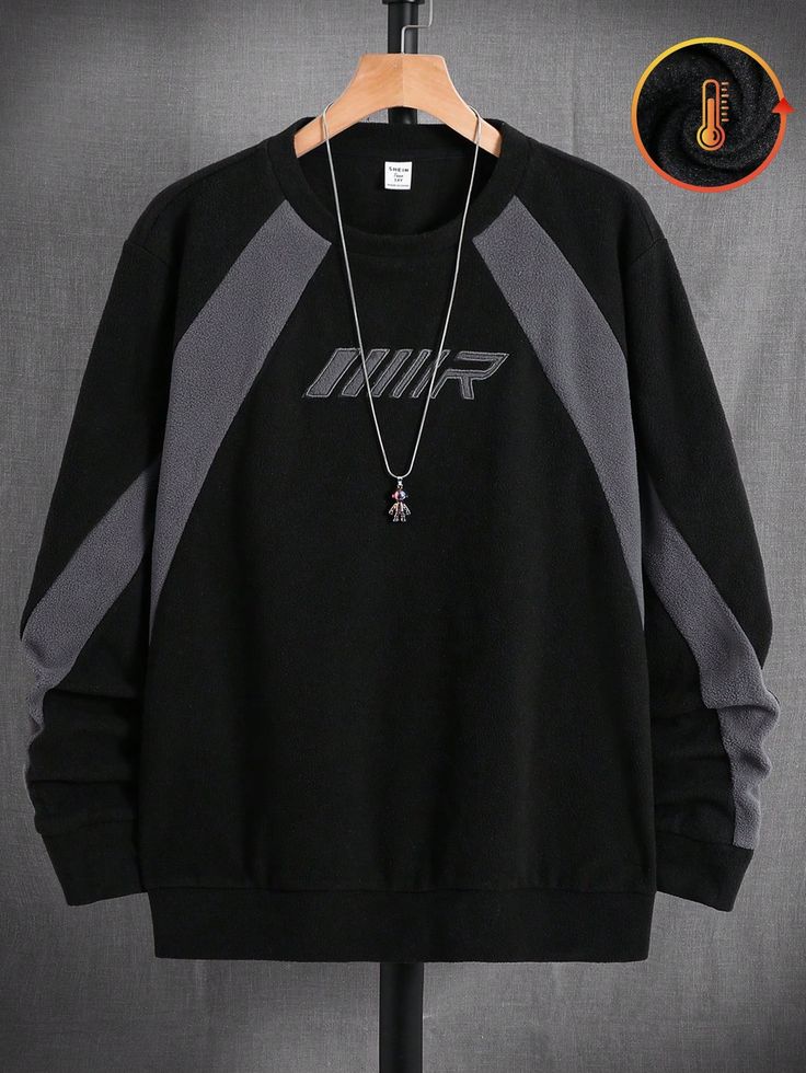 Black and gray sweatshirt with a logo on a hanger against a gray background