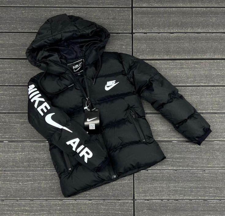 Black puffer jacket with Nike logo on a wooden floor